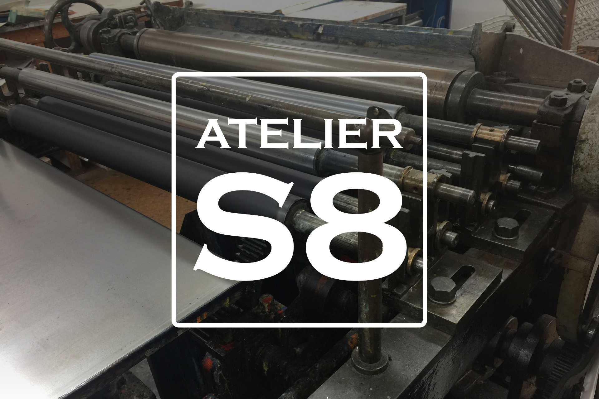 Atelier S8 logo with press rollers background